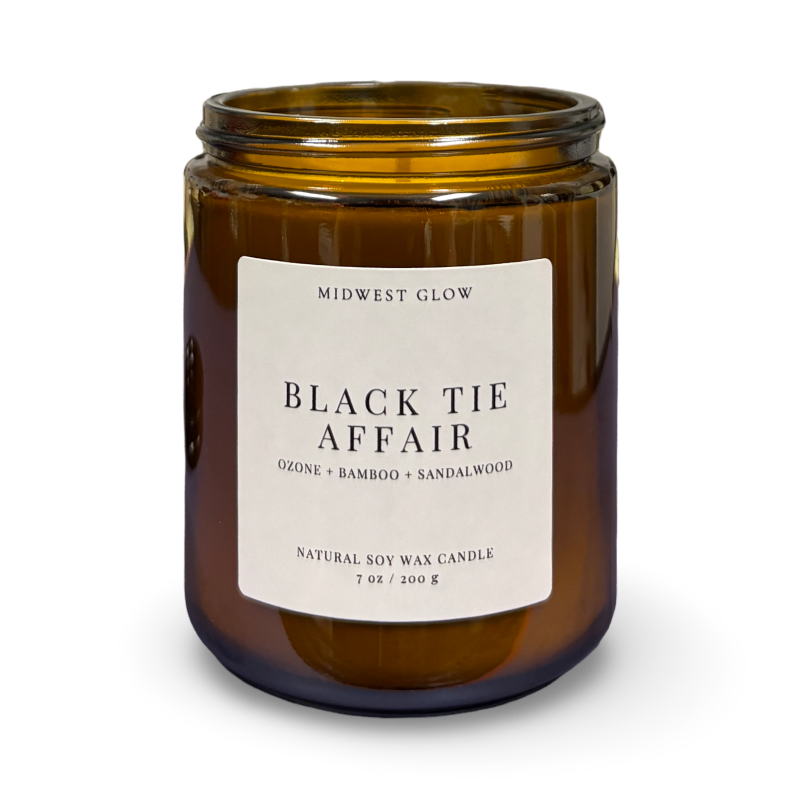 Amber glass candle jar with a label on a white background