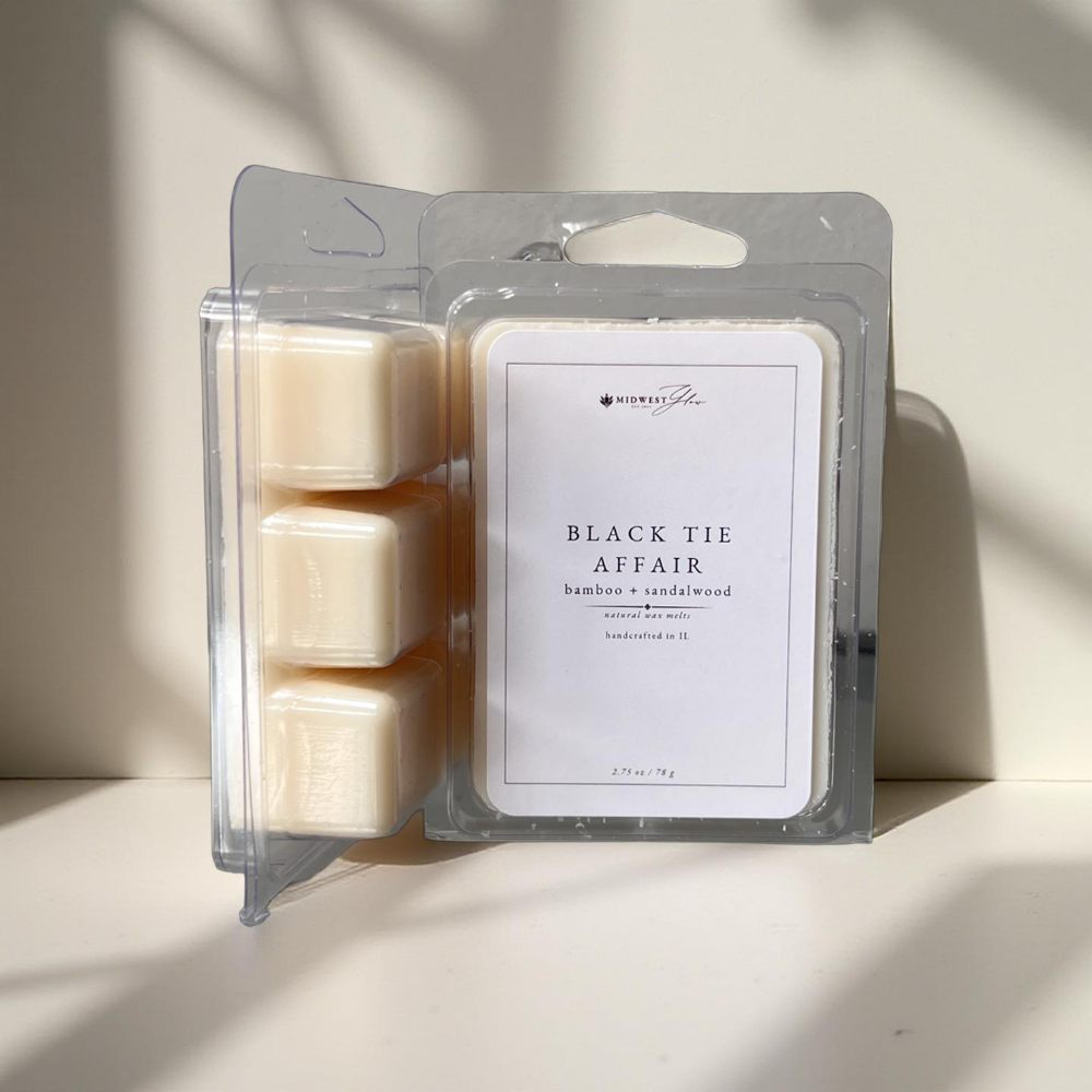 Black Tie Affair Wax Melts by Midwest Glow resting against a white wall with subtle shadows creating a product highlight for the Signature Collection