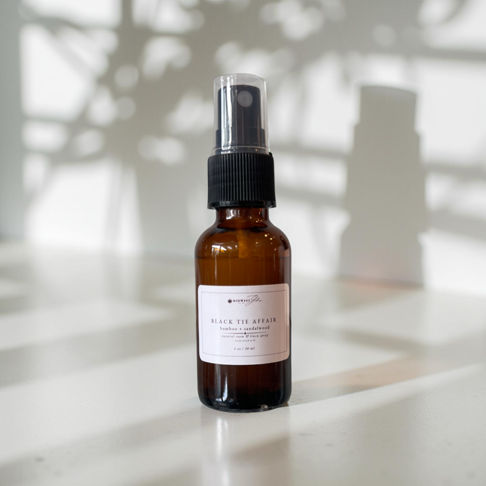 Black tie Affair mini spray sits against a white photo backdrop with subtle shadows highlighting the product