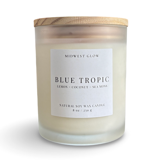 Candle with a wooden lid labeled 'Blue Tropic' by Midwest Glow on a white background