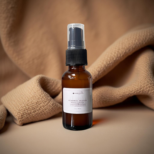 Brown spray bottle with a label on a beige fabric background