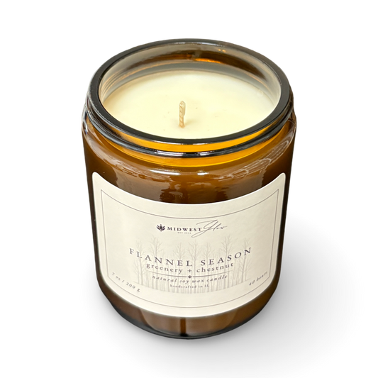Candle in a glass jar with a label on a white background