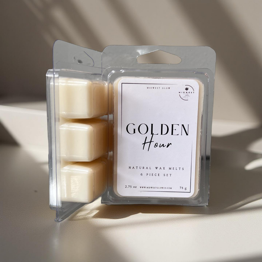 Golden Hour Wax Melts by Midwest Glow displayed against a silky white backdrop with rays of natural light creating shadows and displaying the product