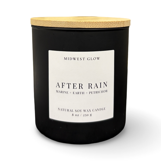 Black candle with a wooden lid labeled 'After Rain' by Midwest Glow on a white background