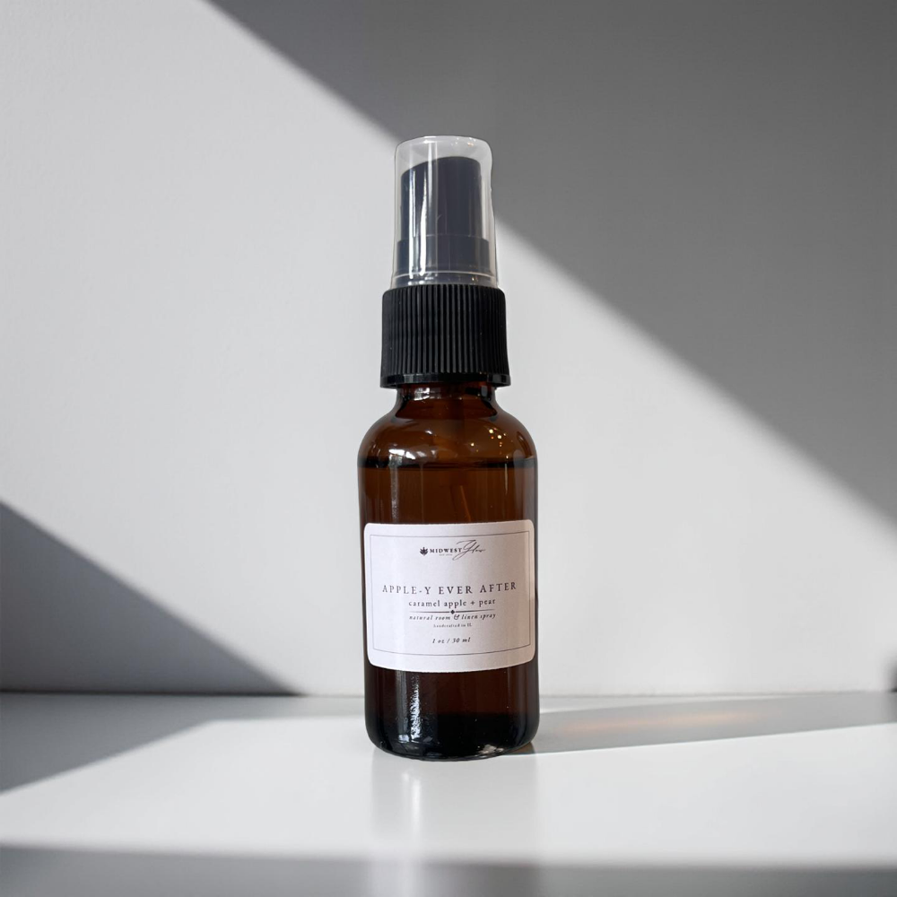 Appley ever after mini room spray by Midwest glow sits against a white photo backdrop with subtle shadows