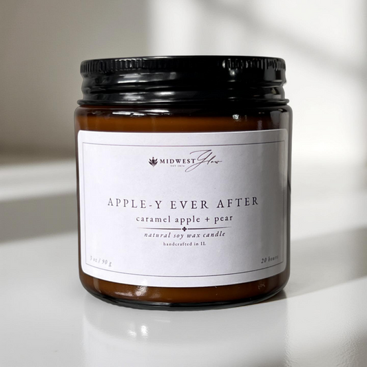 A 3 oz version of the apple-y ever after candle by Midwest Glow sits in front of a white photo backdrop with subtle shadows to showcase the products design