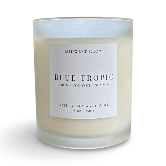 Candle with a label reading 'Blue Tropic' by Midwest Glow on a white background