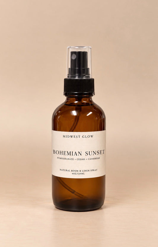 Midwest Glow Bohemian Sunset natural room spray in an amber glass bottle with a black spray cap and a cream label, set against a solid beige background.