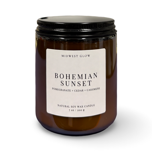 Candle with a label reading 'Bohemian Sunset' on a white background