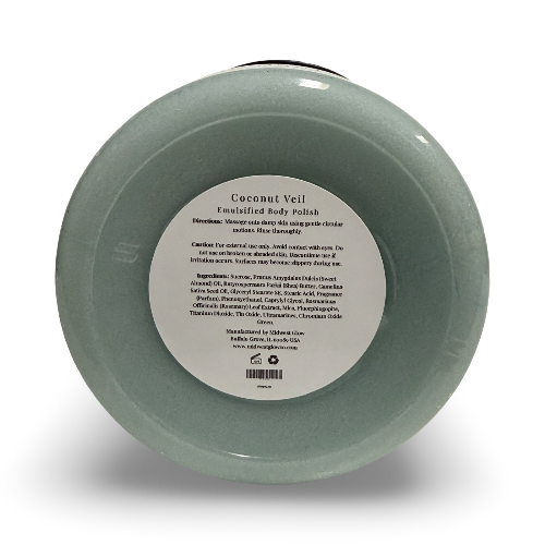 A round, shallow dish-shaped body polish jar with a pale sage green exterior and a white paper label in the center reading 'Coconut Vell Enriched Body Polish.' The product is photographed on a clean white background with a soft drop shadow.