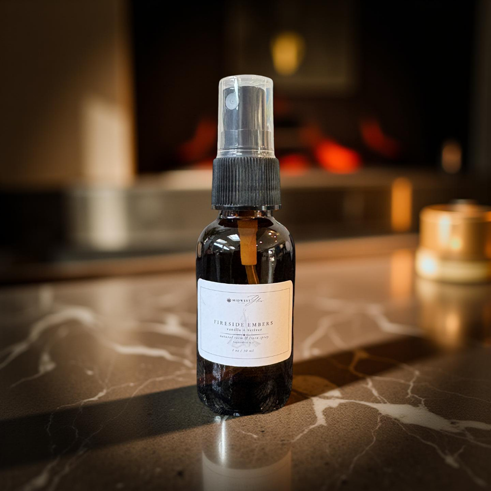 Small black bottle with spray nozzle on a marble surface with a blurred background