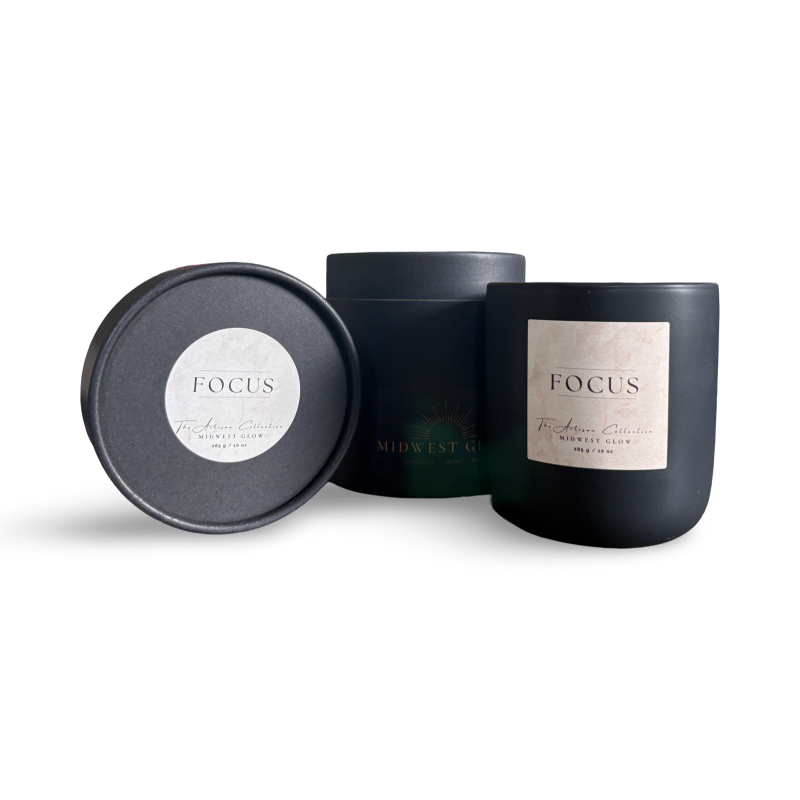Black candle with 'FOCUS' label and matching black lid on a white background