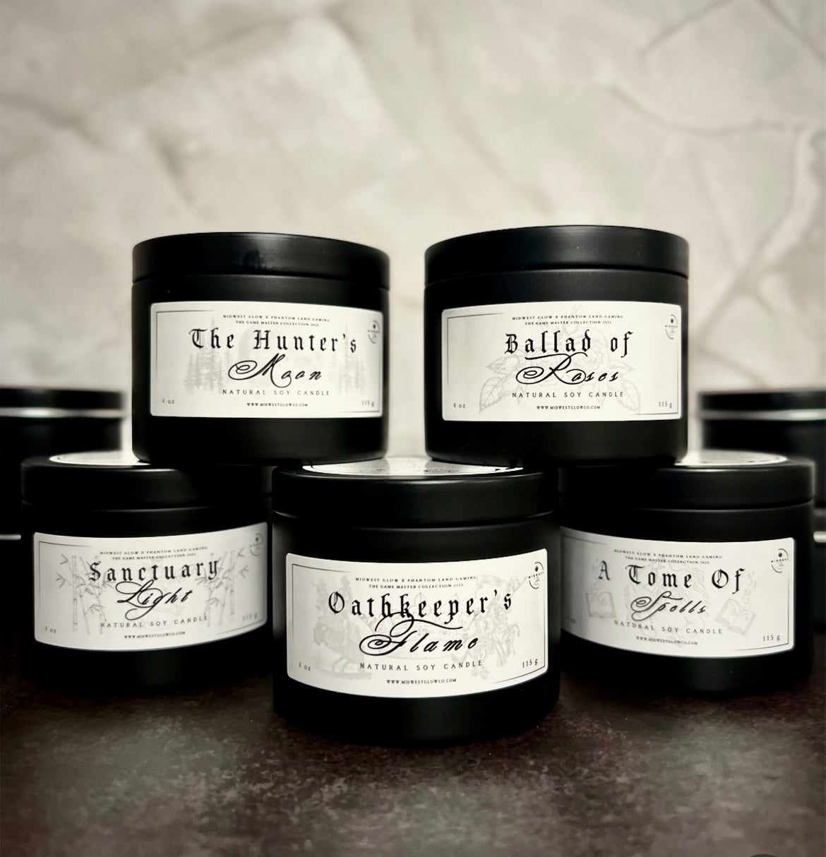 A pyramid shaped display of candles in black tins showing the branding of the Game Master Collection by the company Midwest Glow