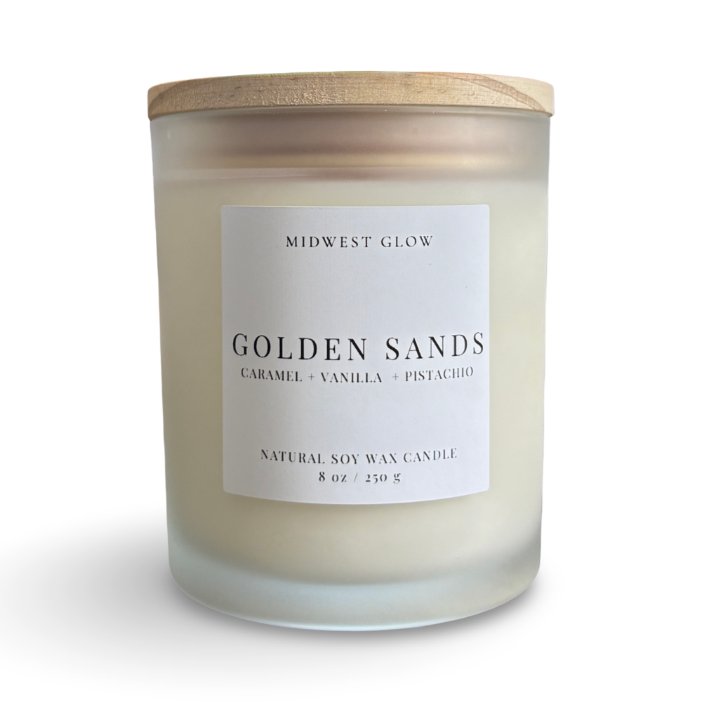 Candle with a wooden lid labeled 'Midwest Glow Golden Sands' on a white background