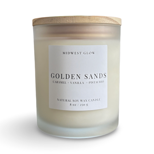 Candle with a wooden lid labeled 'Midwest Glow Golden Sands' on a white background