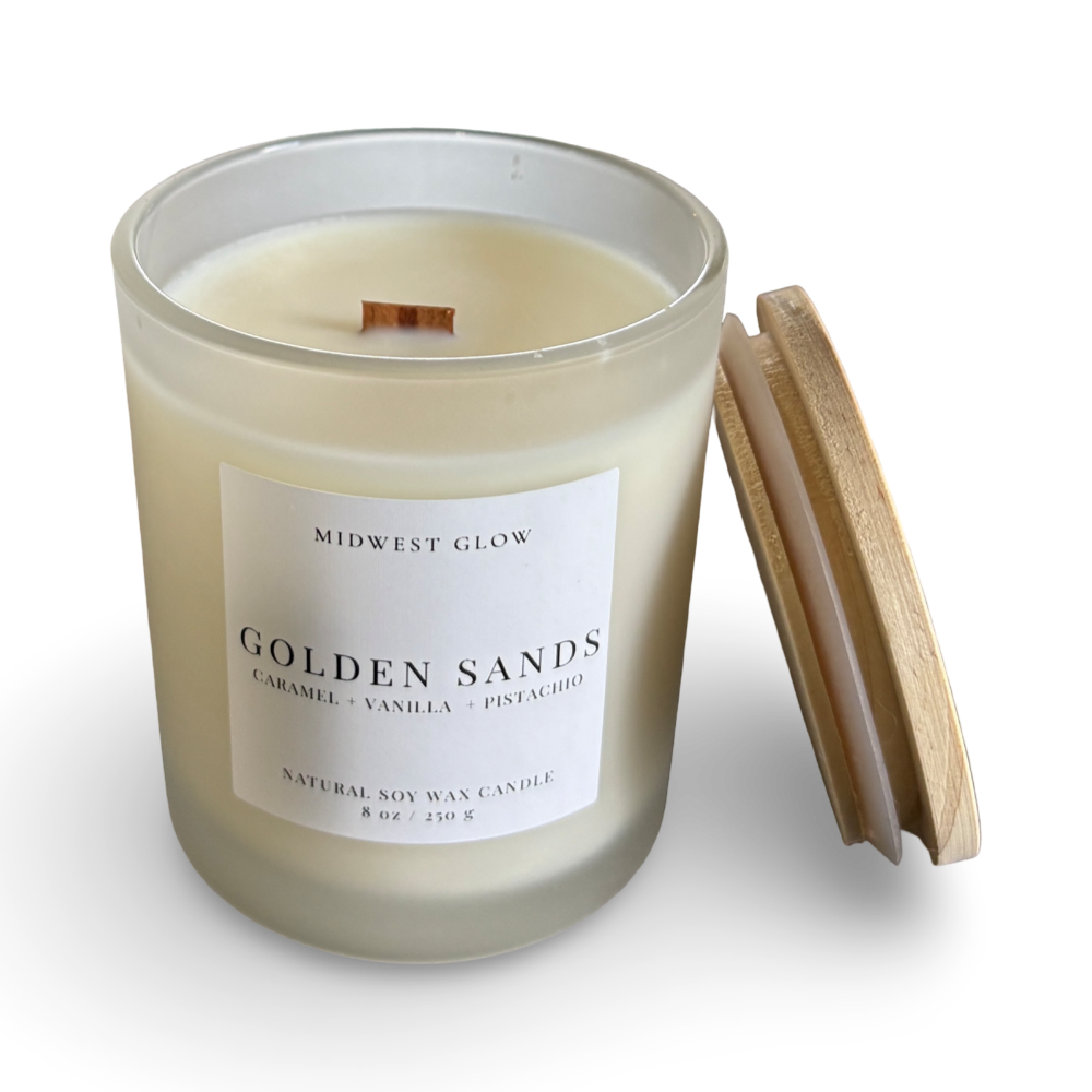 Candle with a wooden lid labeled 'Golden Sands' by Midwest Glow on a white background