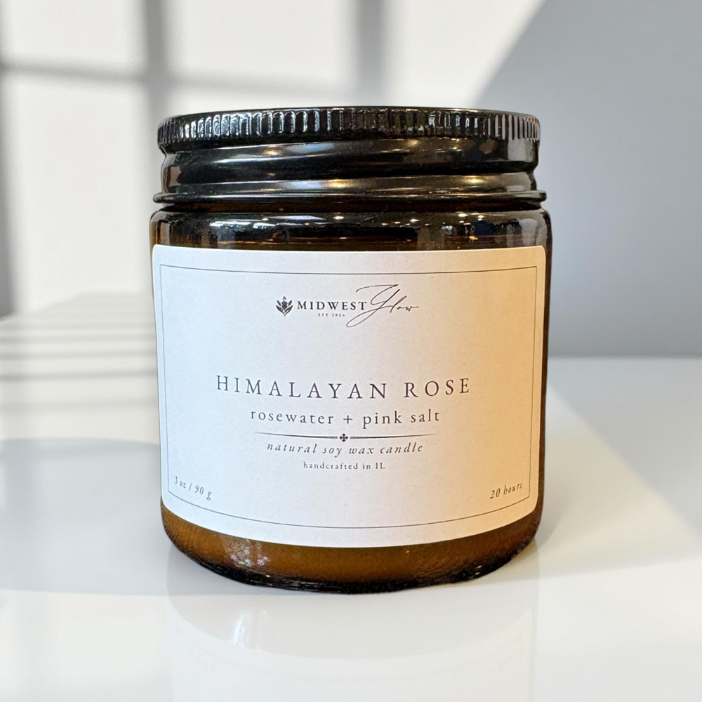 Candle jar labeled 'Himalayan Rose' by Midwest Glow on a white surface.