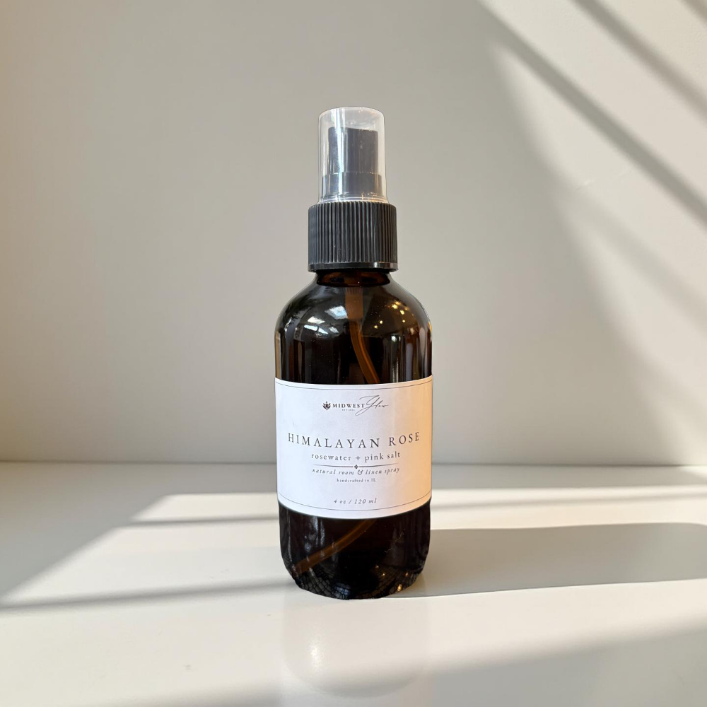 Himalayan Rose essential oil bottle on a white surface with a neutral background