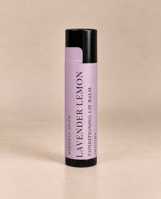 A single tube of Midwest Glow Lavender Lemon Conditioning Lip Balm, featuring a lavender purple label and black cap, set against a solid beige background.