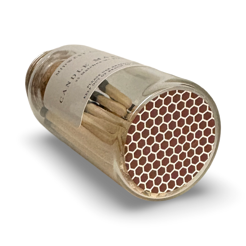 Glass Jar of matches on its side showcasing a honeycomb style strike pad on the bottom of the jar.