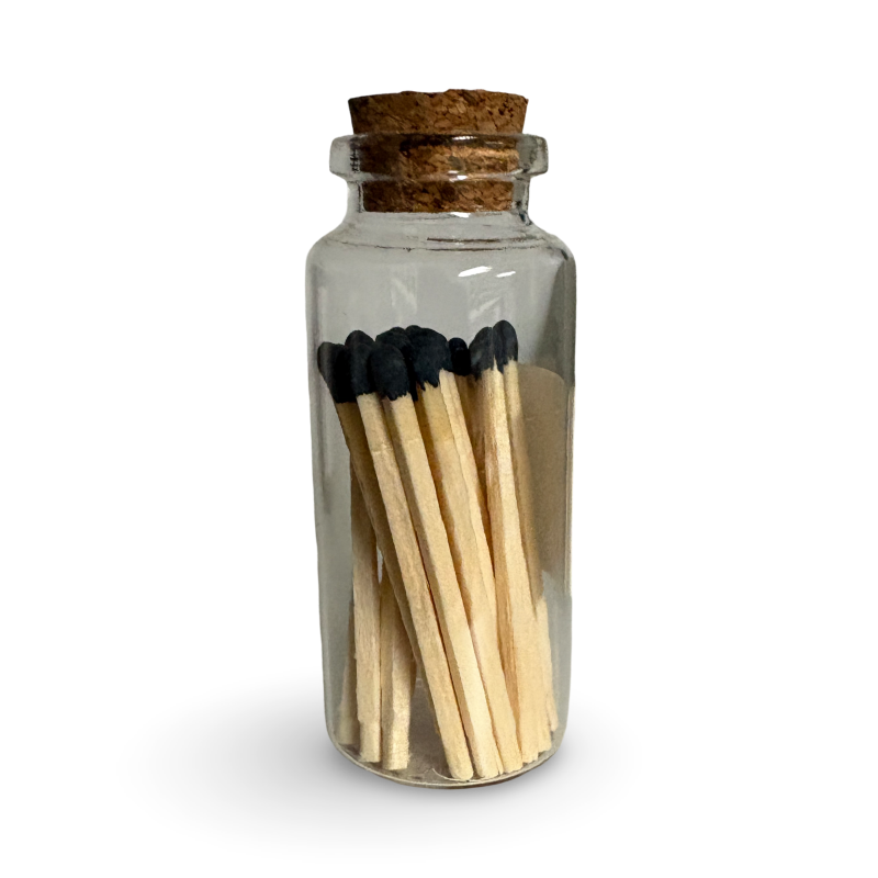 Clear glass jar with cork lid containing matches on a white background